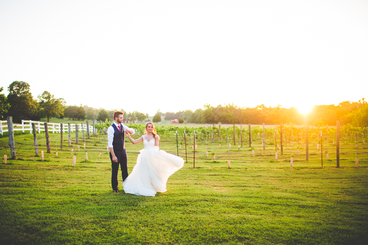 bride twirling during golden hour wedding portraits at vineyard | arkansas wedding photographer 