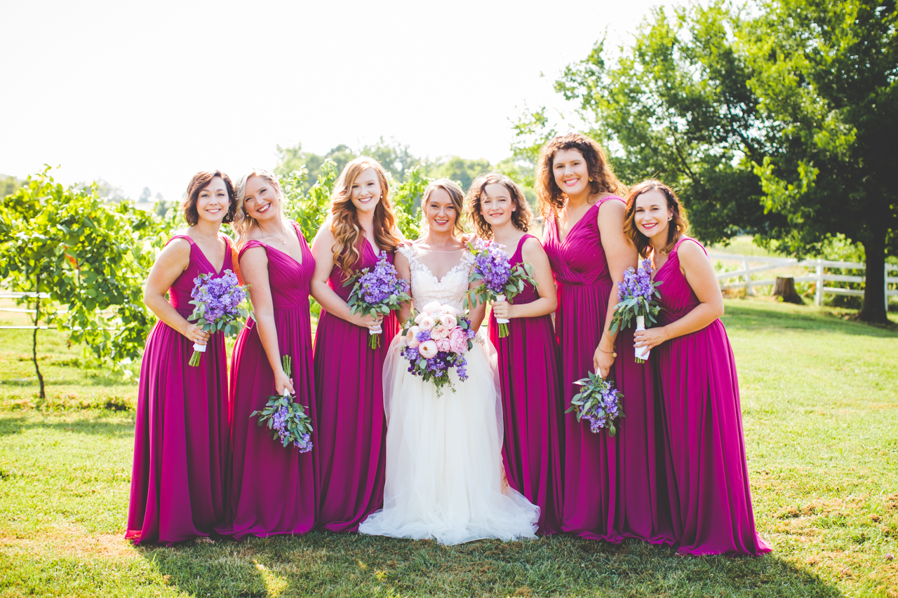 bridesmaids in dark pink wedding dresses with lilac bouquets 