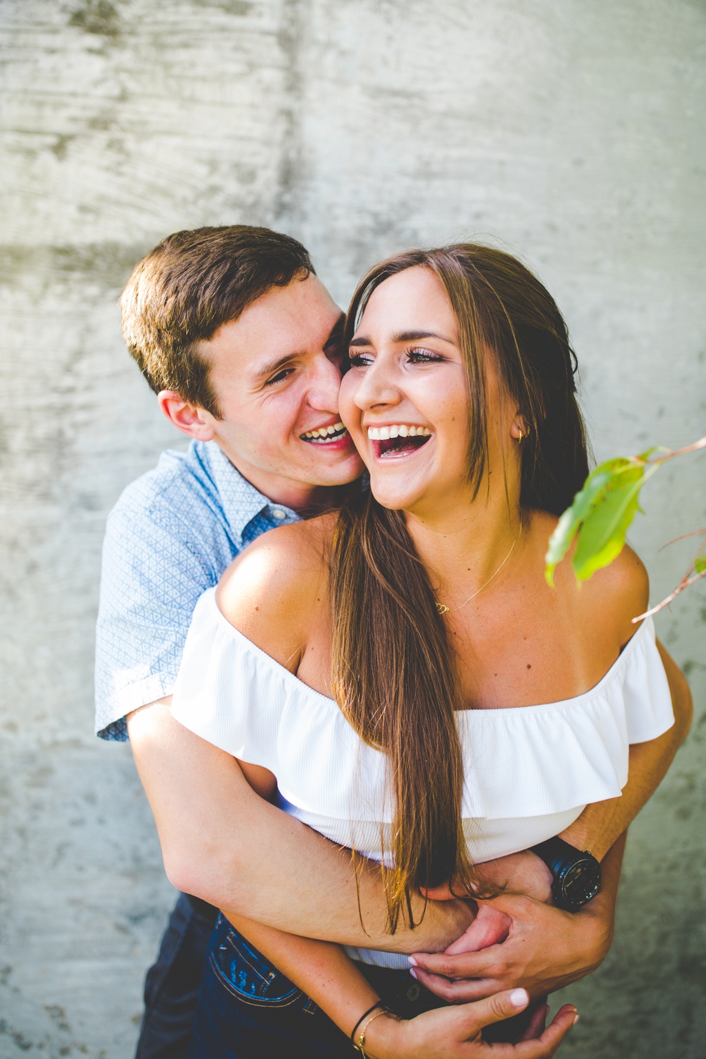 woman laughs during engagement photos