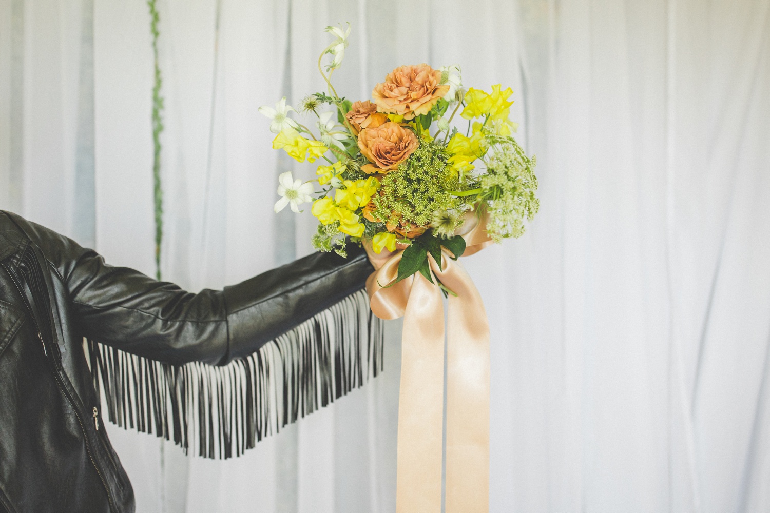 yellow and peach wedding bouquet with leather jacket fringe